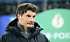 HSV-Trainer Merlin Polzin vor dem Logo des DFB-Pokals.