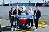 Laura Ludwig, Henrik Köncke, Dino Hermann, Michael Papenfuß und Eric Huwer am Elbufer mit einem Schal in ihren Händen