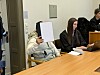 Navid M. sitzt neben seiner Verteidigerin im Landgericht. Er hält sich eine Mappe vor das Gesicht.