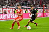 Raphael Guerreiro von Bayern München im Zweikampf mit Arkadiusz Pyrka von St. Pauli vor einer TV-Kamera von Sky