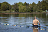 Ein Mann macht sich im Stadtparksee bereit zum Schwimmen.