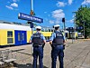 Zwei Polizisten stehen am Bahnhof Hamburg-Harburg neben einem vorbeifahrenden Regionalzug.
