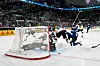 Deutsche und finnische Spieler schauen dem Puck hinterher, der vor dem Tor liegt