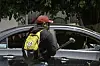 Ein maskierter Lehrer zerstört ein Auto mit einem Hammer