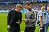 HSV-Vorstand Eric Huwer (l.) und Sportdirektor Claus Costa schauen vor der Partie gegen Freiburg auf ihre Smartphones.