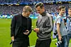 HSV-Vorstand Eric Huwer (l.) und Sportdirektor Claus Costa schauen vor der Partie gegen Freiburg auf ihre Smartphones.