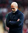 Pep Guardiola mit verschränkten Armen und Blick nach unten