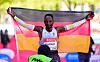 Samuel Fitwi mit einer Deutschland Flagge nach seinem Zieleinlauf
