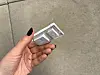 Eine Hand hält den ausgebauten Ein/Aus-Schalter der Waschmaschine