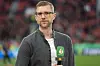 Per Mertesacker mit ZDF-Mikrofon vor unscharfem Stadionhintergrund in der BayArena.