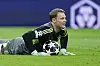 Manuel Neuer liegt nach einem gehaltenen Ball mit einem Lächeln auf dem Rasen.