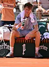 Jannik Sinner sitzt erschöpft auf einem Stuhl