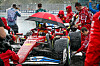 Der Ferrari von Lewis Hamilton wird mit einem Schirm vor dem Regen geschützt.