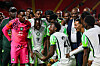 Philip Otele feiert mit Pokal in der Hand zusammen mit der nigerianischen Nationalmannschaft.