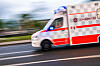Johanniter-Rettungswagen mit Blaulicht fährt auf einer Straße.