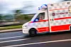 Johanniter-Rettungswagen mit Blaulicht fährt auf einer Straße.