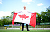 Kanada-Fan hält vor dem Stadion die rot-weiße Flagge mit Ahornblatt hoch