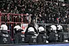 Polizisten in Schutzhelmen vor dicht gedrängten Hannover-Fans im Stadion