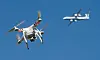 Eine private Drohne fliegt in weiter Entfernung von einem Flugzeug.