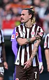 Jackson Irvine steht mit verschränkten Armen im St.-Pauli-Trikot nach dem 1:3 gegen Wolfsburg.
