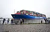 Passanten beobachten im Hamburger Hafen, wie die »Cosco Shipping Virgo« zum Terminal Tollerort geschleppt wird.