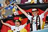 Zwei junge deutsche Fans halten im Stadion die Deutschlandfahne hoch.