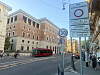 ZTL-Schild in Rom mit Innenstadtstraße, Bus, Autos und historischen Gebäuden im Hintergrund.