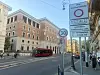 ZTL-Schild in Rom mit Innenstadtstraße, Bus, Autos und historischen Gebäuden im Hintergrund.
