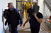 Mann wird im Hamburger Strafjustizgebäude von zwei Begleitern zum Gerichtssaal geführt.