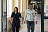 Beamtin begleitet gepixelten Angeklagten im Hamburger Strafjustizgebäude zum Gerichtssaal.