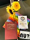 Ein jüdisches Gebetsbuch liegt auf einer Regenbogen-Serviette