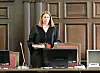 Richterin Isabel Hildebrandt steht im Sitzungssaal des Landgerichts Hamburg vor Holzvertäfelung.