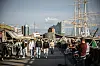 Menschen gehen an den Landungsbrücken in Hamburg bei Sonnenschein