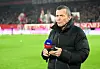 Lothar Matthäus steht mit seinem Handy und einem Sky-Mikrofon in der Hand auf dem Spielfeld.