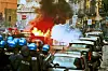 Die Polizei rückt an die Fans näher ran. Ein Auto steht in Flammen.
