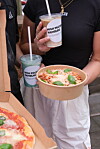 Personen mit Bechern und einer Essensschale von High Protein Hamburg an einem Streetfood-Stand.