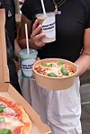 Personen mit Bechern und einer Essensschale von High Protein Hamburg an einem Streetfood-Stand.