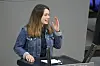 Junge Frau in Jeansjacke spricht im Bundestag