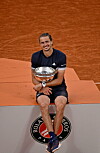 Alexander Zverev sitzt mit der Trophäe auf dem Podest in Roland Garros nach dem French-Open-Finale.