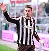 Fußballspieler im braun-weiß gestreiften Trikot winkt im Stadion und hält eine Trinkflasche.