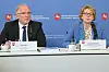 Daniela Behrens und Dirk Pejril sitzen vor blauer Behördenwand bei der Vorstellung des Verfassungsschutzberichts in Niedersachsen.