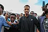 Omar Abdulkadir Artan steht in Mogadischu vor jubelnden Fans, viele halten Smartphones hoch.