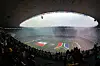 Estadio Azteca in Mexiko-Stadt mit Fahnen auf dem Rasen und vollen Tribuenen zur Eroeffnungsfeier.
