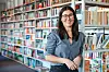 Lehrerin Julia Köster steht vor Bücherregalen in der Schulbibliothek.