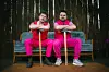 Lukas Klaschinski und Timo Neitzel sitzen in pinken Trainingsanzügen auf einem Sofa.