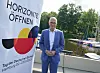 Hamburgs Bürgermeister Peter Tschentscher neben einem Plakat zum Tag der deutschen Einheit.