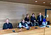 Die drei Angeklagten im Prozess wegen mutmaßlicher Beleidigung von Drosten mit ihren Anwälten.