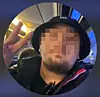 Mann mit Hut zeigt in nächtlicher Umgebung ein Friedenszeichen in die Kamera.