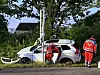 Rettungskräfte sichern ein auf der Seite liegendes Auto am Straßenrand.