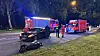 Polizei und Feuerwehr an Unfallstelle mit beschädigtem Motorrad und Einsatzfahrzeugen bei Nacht.